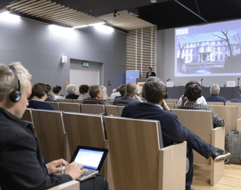 Grupa dorosłych osób na sali audytoryjnej 