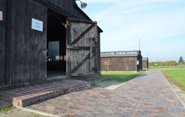 Wejście do baraku więźniarskiego, dwuprzęsłowa drzwi, otwarta jedna strona, wysoki betonowo kamienny stopień