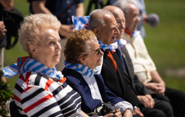 Grupa starszych osób z chustami w niebiesko-białe pasy