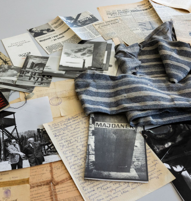A collection of items: photographs, handwritten letters, documents, newspaper articles, and a piece of fabric. 