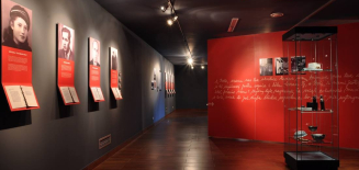 Ekspozycja złożona z czerwonych paneli oraz zdjęć przedstawiających portrety kobiet i mężczyzn