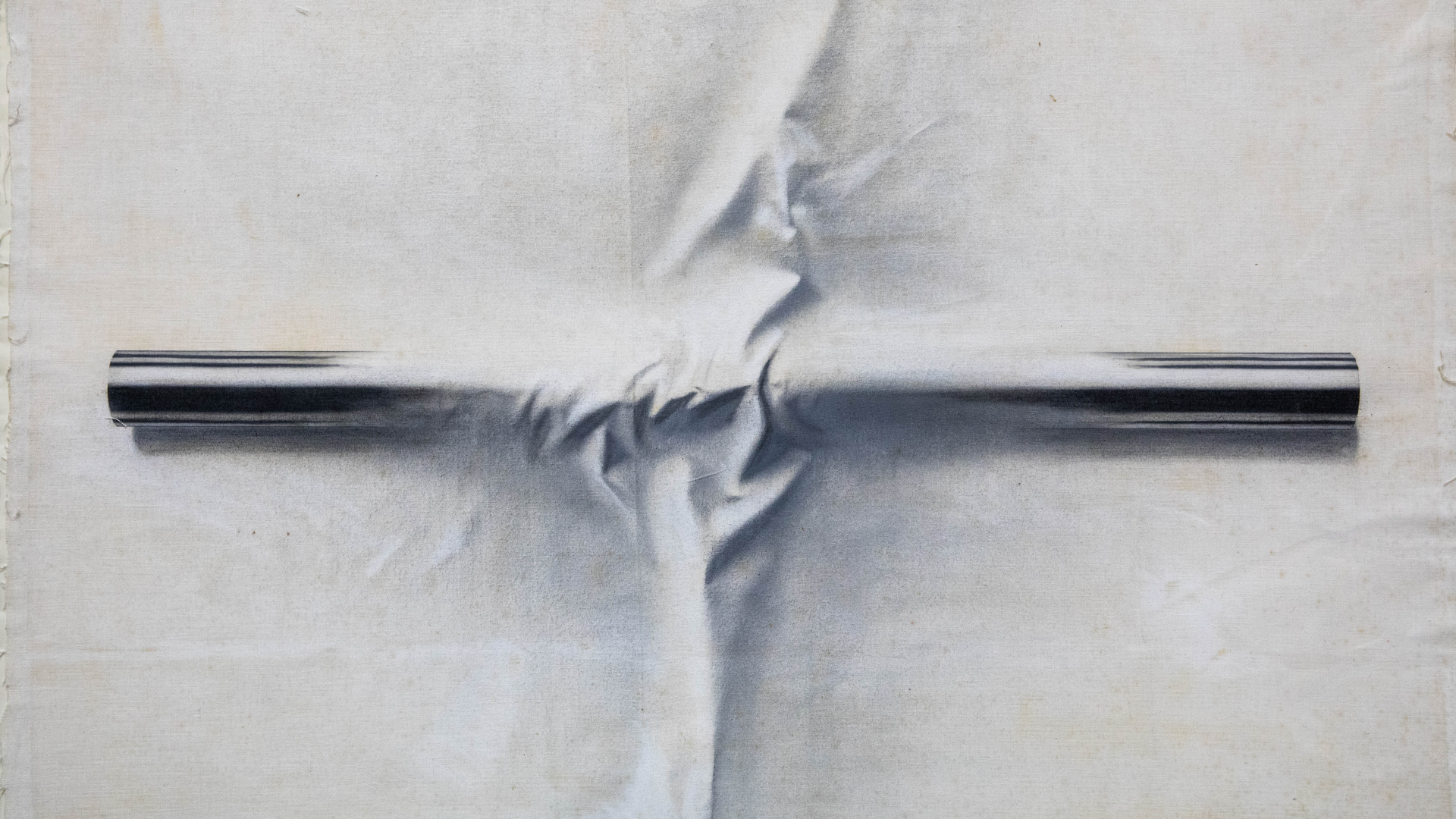 Grafika, wydłużony usytuowany poziomo kształt, który imituje metal przecina i wtapia się w jasne tło przypominające zmięty papier lub materiał