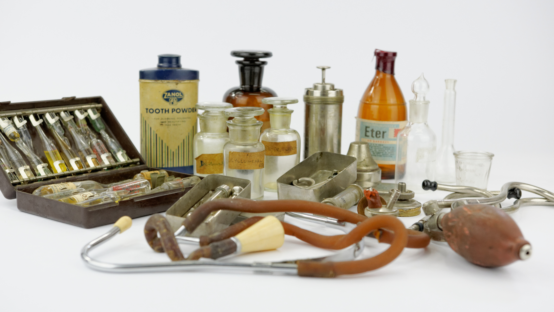 Zdjęcie przedstawiające używane w obozie przyrządy medyczne, stetoskop, buteleczki na leki, strzykawki 