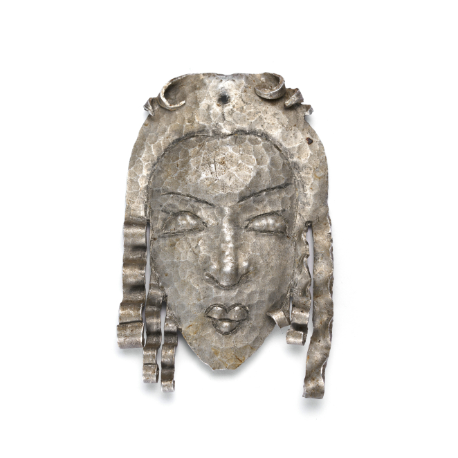 Metalowa głowa kobiety o długich falowanych włosach i wydatnych ustach 