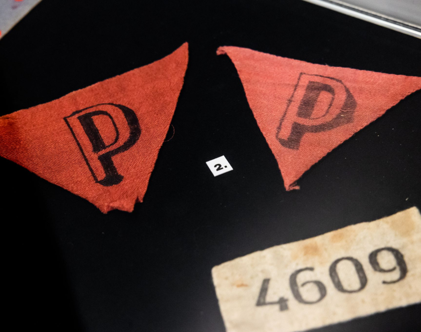 Trzy czerwone trójkąty z literą P na czarnym tle