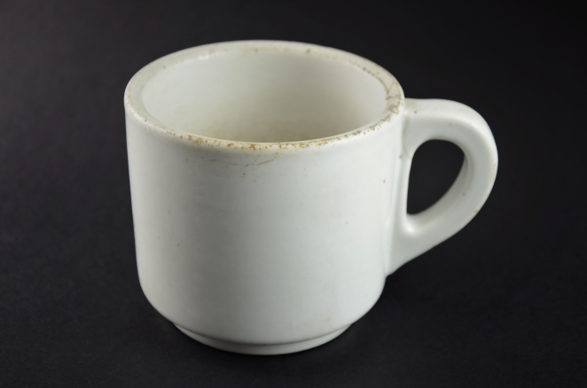 Biały kubek z uchem na ciemnym tle