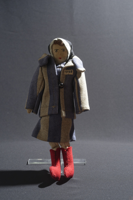 Lalka ubrana w sukienkę - pasiak, chustę na głowie i czerwone buty 