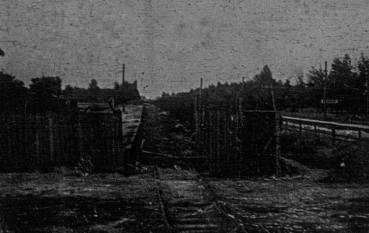 Fragment drewnianego ogrodzenia pośrodku tory