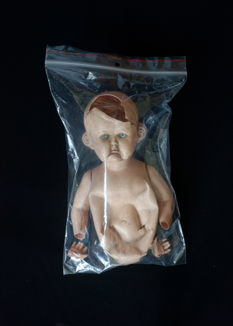 Zniszczony korpus lalki w plastikowym worku strunowym