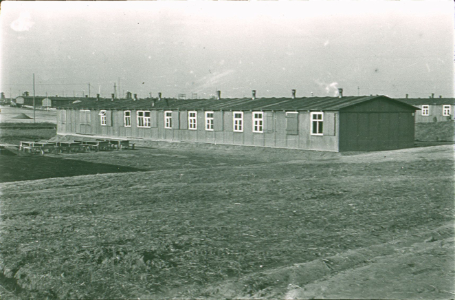 A single-story guard booth with a roofed porch. Behind it is a guard tower.