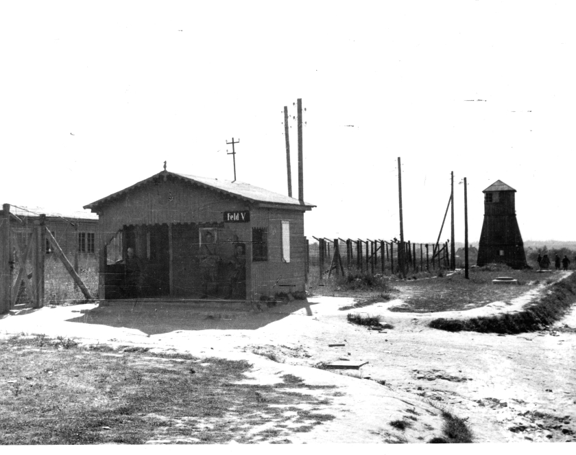 Parterowa budka wartownicza z gankiem pokrytym dachem. Za nią wieżyczka wartownicza