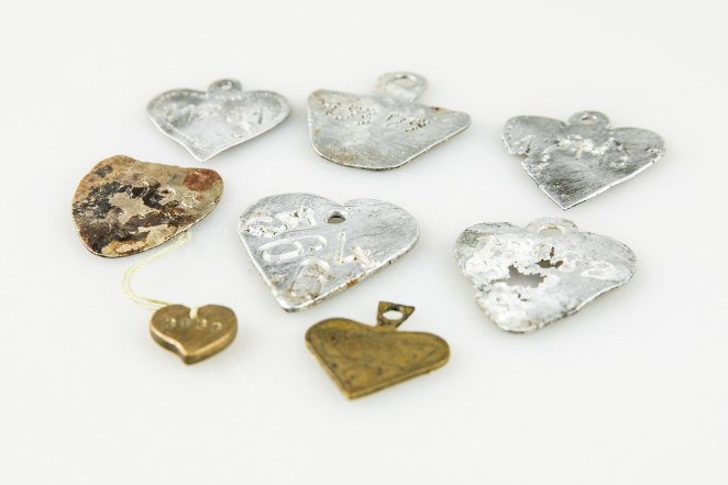 Osiem metalowych blaszek w kształcie serca.