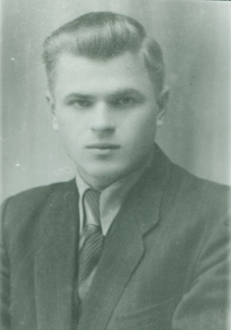 Młody mężczyzna o zaczesanych do tyłu jasnych włosach 