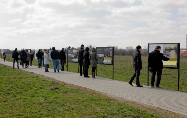 Grupa kilkudziesięciu osób przy panelach wystawy 
