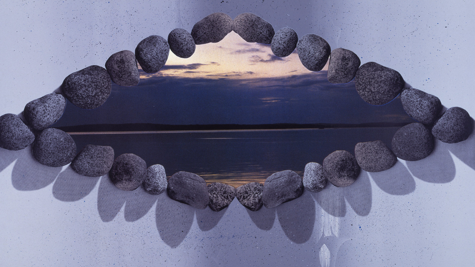 Na niebieskiej kartce w formie okaz ułożone okrągłe kamienie, w środku fotografia z morzem i niebem 