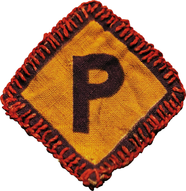 Kawałek żółtego materiału z czarną literą P, dookoła haft wykonany czerwoną nicią