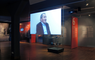 Wnętrze wystawy, panel multimedialny z relacją wideo