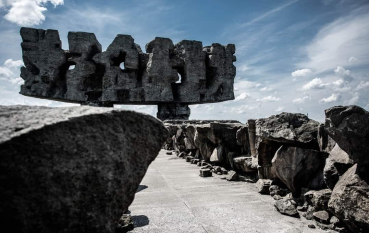 Kamienne głazy ułożone w rzędzie pośrodku góruje Pomnik-Brama (abstrakcyjna forma z kamienia). 
