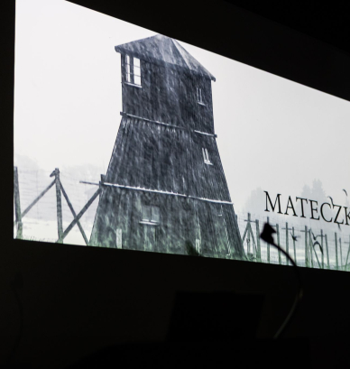 Ekran kinowy, na nim wieża wartownicza i napis Mateczki 
