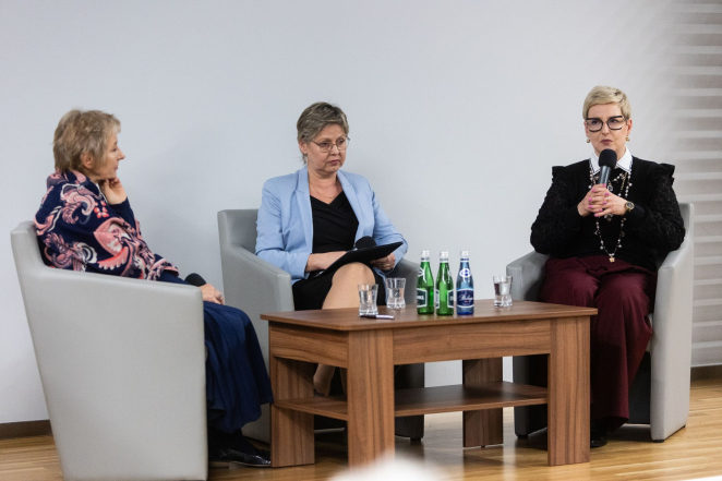 Trzy kobiety podczas rozmowy, jedna trzyma mikrofon