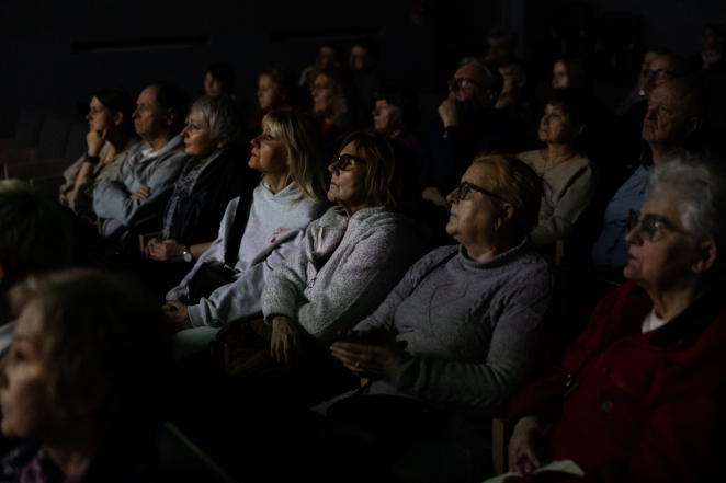 Grupa osób na sali audytoryjnej