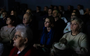 Ciemna sala, kilkanaście osób w różnym wieku oglądających pokaz filmu