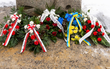 Pięć wiązanek; cztery z bukietem z czerwonych róż oraz wstążkami biało-czerwoną oraz białą, jedna - żółte kwiaty żółto niebieska wstęga.