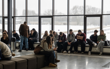Młodzież w Centrum Obsługi Zwiedzających, dookoła duże przeszkolone okna.