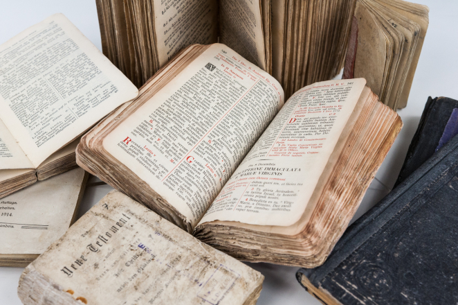 Kilka rozłożonych książek ze zniszczonymi brzegami