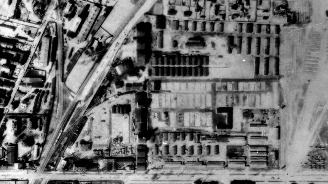 Zdjęcie lotnicze pokazujące ulice i rzędy budynków. Po lewej stronie widoczne są tory z bocznicą kolejową