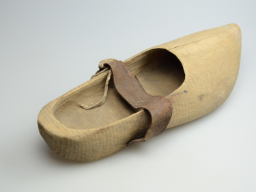 Zdjęcie buta wykonanego w całości z drewna ze spiczastym nosem i paskiem podtrzymującym zamocowanym w połowie długości buta