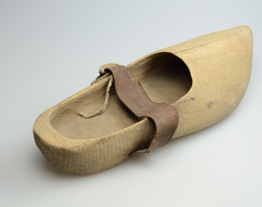 Zdjęcie buta wykonanego w całości z drewna ze spiczastym nosem i paskiem podtrzymującym zamocowanym w połowie długości buta