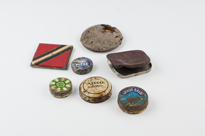 Zdjęcie zniszczonych opakowań po kosmetykach. Okrągłe i prostokątne pojemniczki