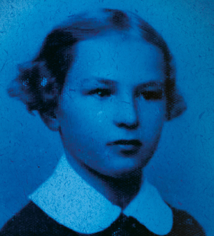 Niebieskie zdjęcie kilkuletniej dziewczyny o włosach upiętych w koszyczki nad uszami 