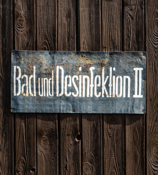 Drewniana ściana na niej tablica z napisem: Bad und desinfektion II