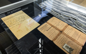 Dwa pożółkłe dokumenty w przeszklonej gablocie.