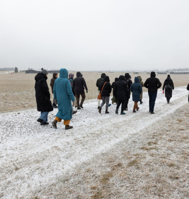Grupa osób na terenie byłego obozu koncentracyjnego na Majdanku. 