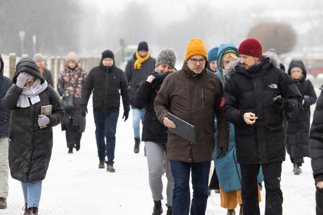 Grupa osób w średnim wieku w zimowych kurtkach i czapkach. 