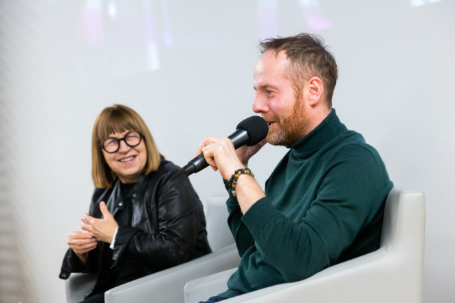 Kobieta w okularach i mężczyzna przemawiający do mikrofonu 