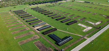 Zdjęcie z lotu ptaka, na pierwszym planie planie rzędy baraków oraz ich pozostałości, na drugim zabudowa miejska 