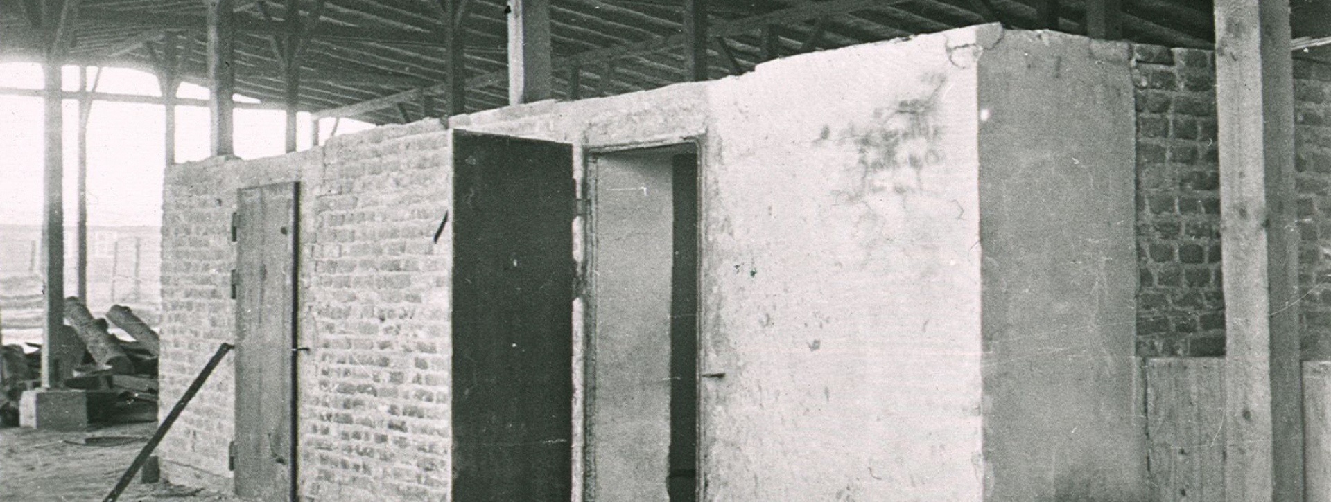 Prostokątna ceglasta zabudowa , dwie pary drzwi oraz wiata zakrywająca budowlę 