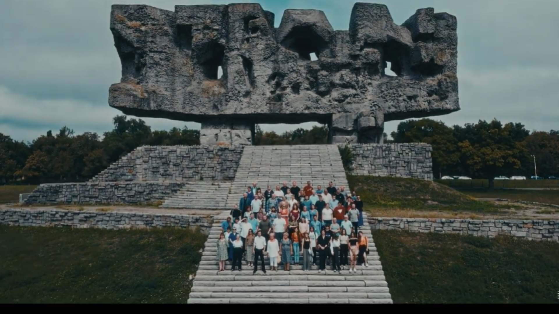 Grupa ludzi na tle Pomnika Bramy 