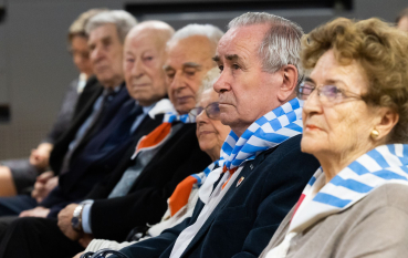 Grupa byłych więźniów na sali audytoryjnej