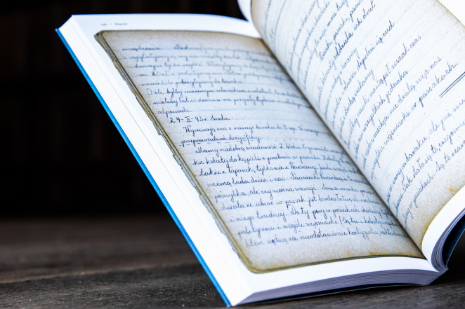 Otwarta książka, odręcznie napisane kartki papieru 