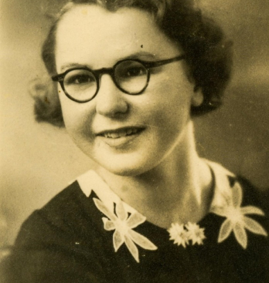 Portret młodej kobiety w okularach o okrągłych szkiełkach 