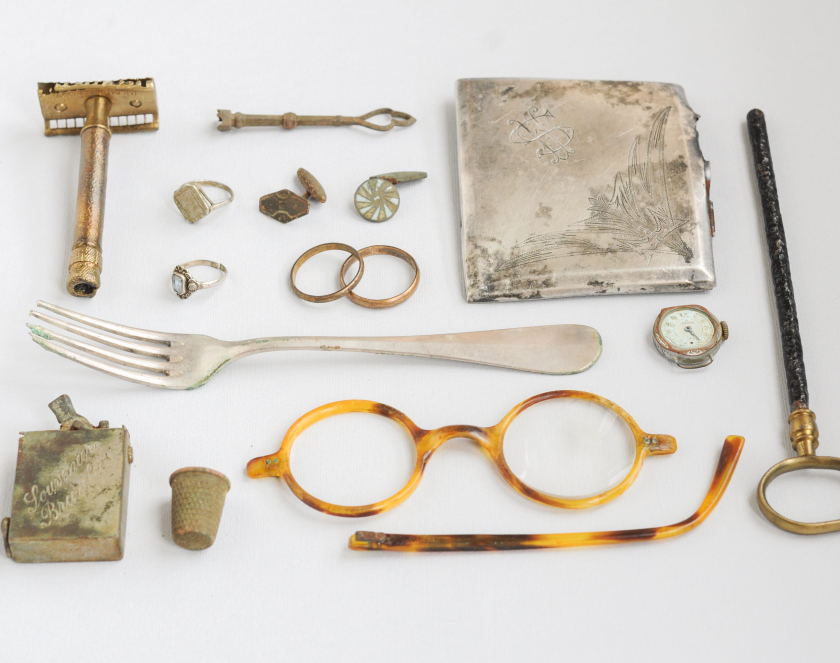 Zbiór przedmiotów: maszynka męska do golenia, klucz, papierośnica, widelec, okulary, naparstek, zapalniczka, biżuteria, zegarek