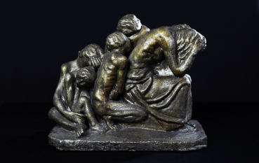 Metalowa rzeźba, grupa osób przytulona do siebie plecami, zakrywająca twarz.