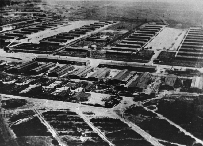 Zdjęcie lotnicze, czarno-białe. Rzędy drewnianych baraków