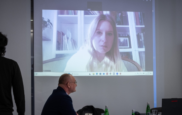 Sala edukacyjna, na ekranie kobieta o długich blond włosach. 