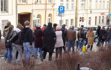 Grupa kilkudziesięciu osób idących ulicą.